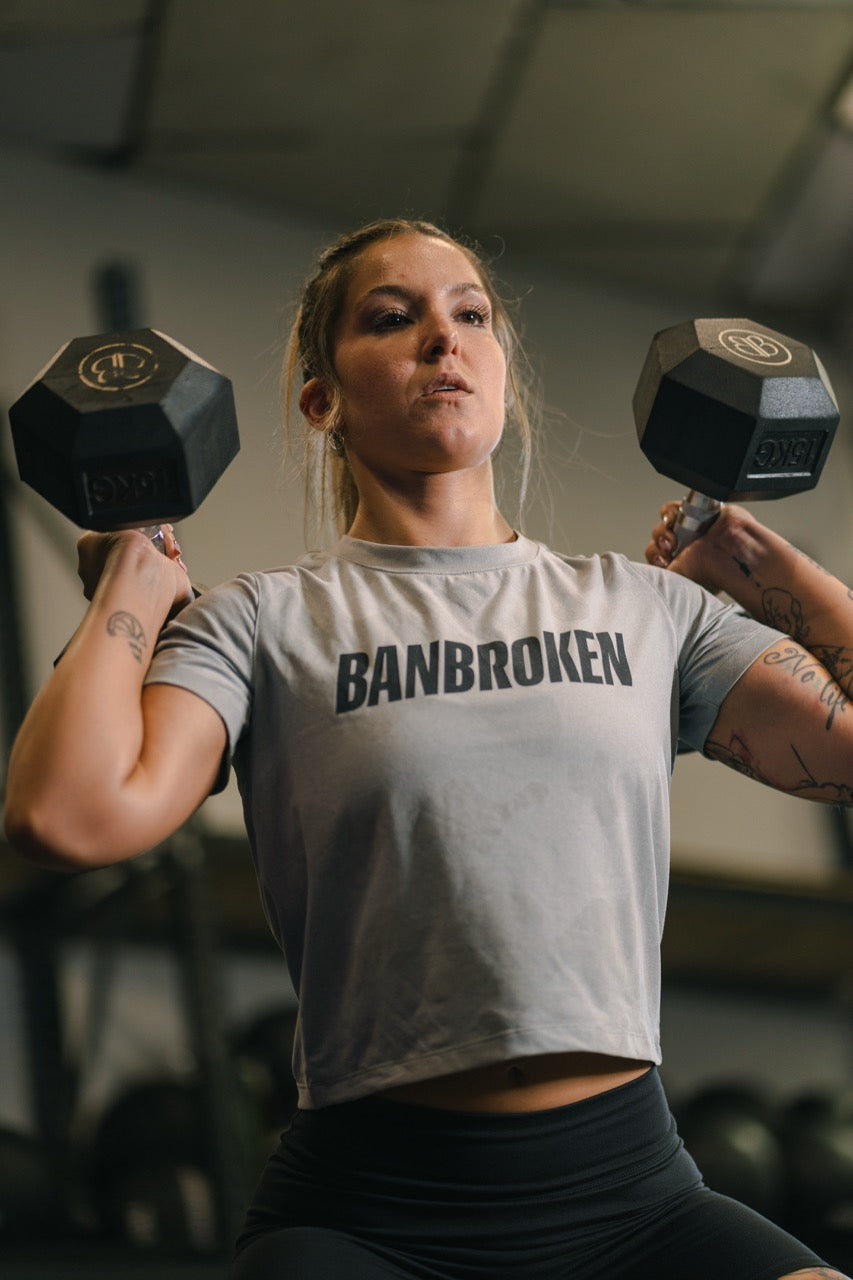 Mujer con conjunto de entrenamiento Banbroken levantando mancuernas